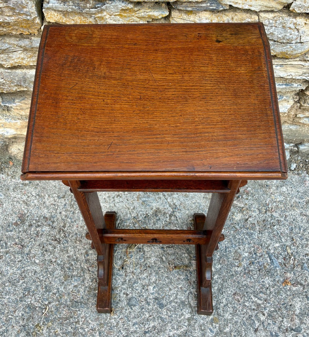A small antique dark oak church lectern featuring a slanted reading top, trefoil cutouts, and a trestle base. View II