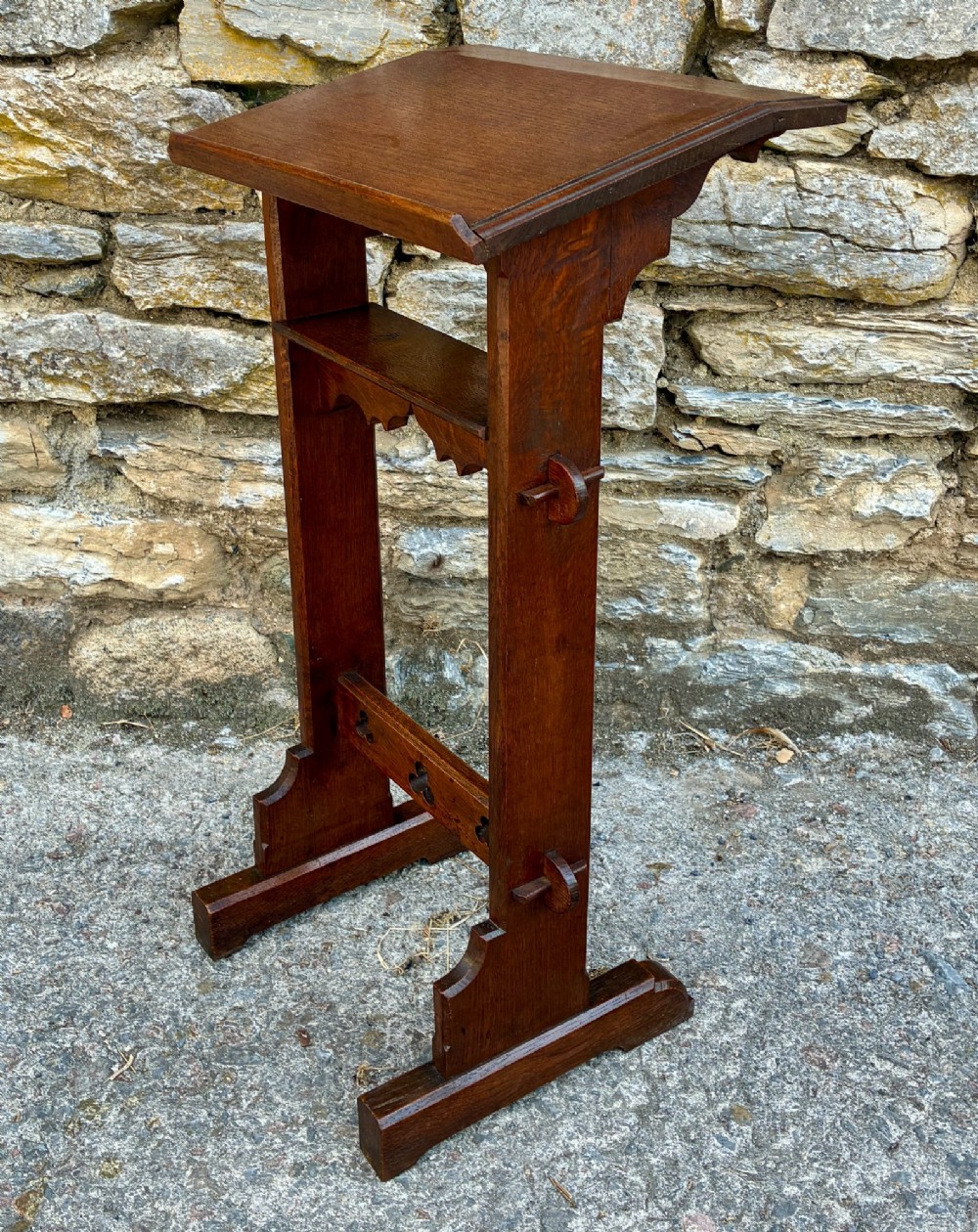 A small antique dark oak church lectern featuring a slanted reading top, trefoil cutouts, and a trestle base. View III
