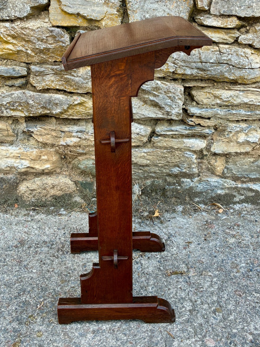 A small antique dark oak church lectern featuring a slanted reading top, trefoil cutouts, and a trestle base. View IV