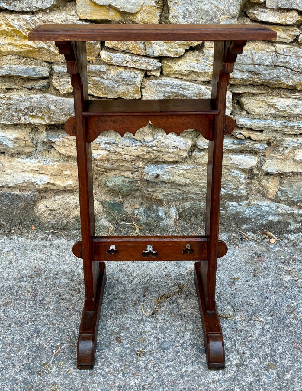 A small antique dark oak church lectern featuring a slanted reading top, trefoil cutouts, and a trestle base. View V