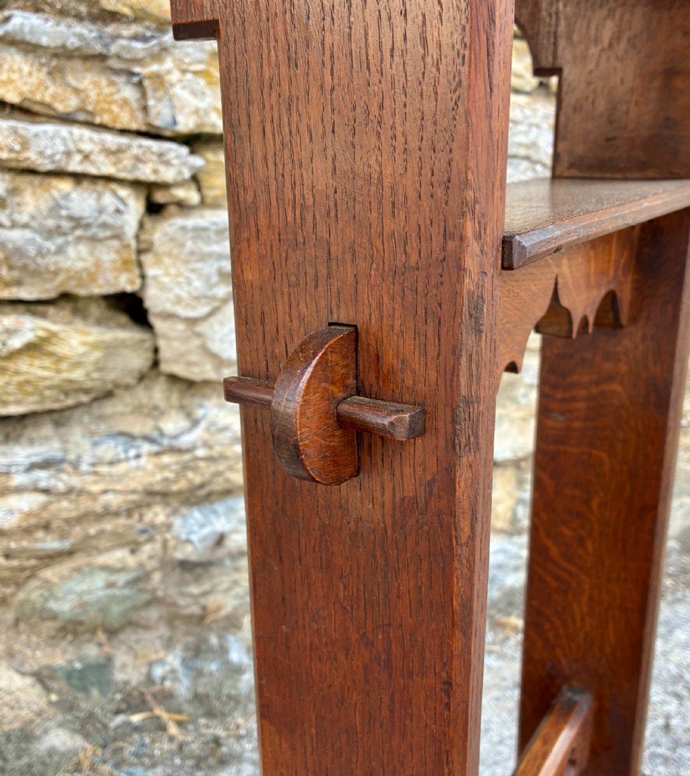 A small antique dark oak church lectern featuring a slanted reading top, trefoil cutouts, and a trestle base. View VII