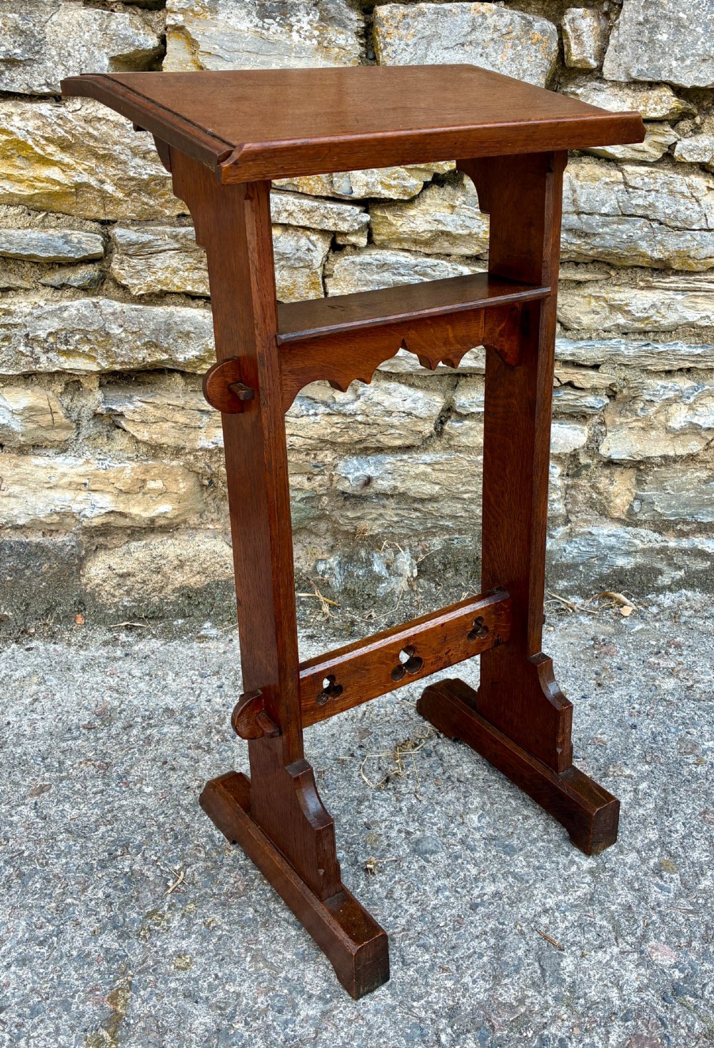 A small antique dark oak church lectern featuring a slanted reading top, trefoil cutouts, and a trestle base. View VIII