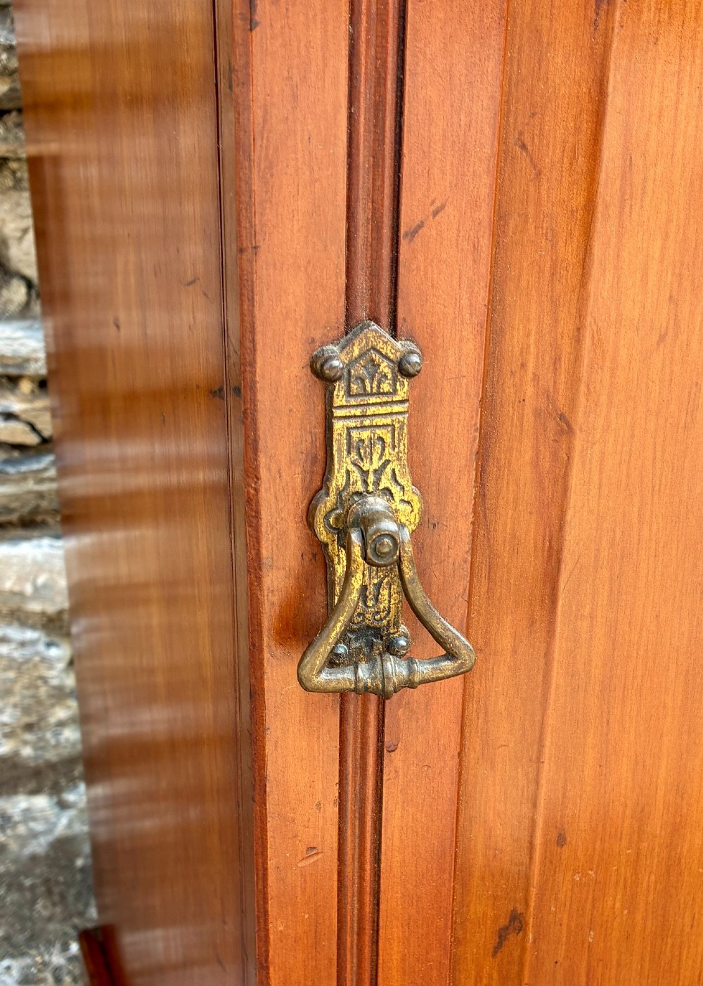 An Edwardian warm brown walnut pot cupboard featuring a single panelled door with a brass handle and reeded side moulding. View IV