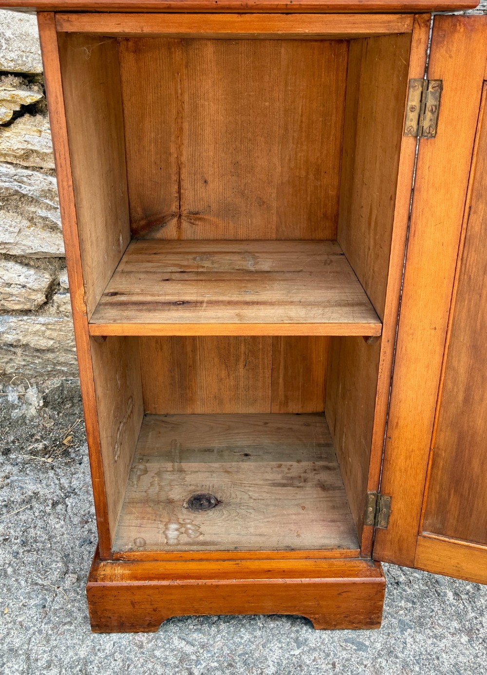 An Edwardian warm brown walnut pot cupboard featuring a single panelled door with a brass handle and reeded side moulding. View VI