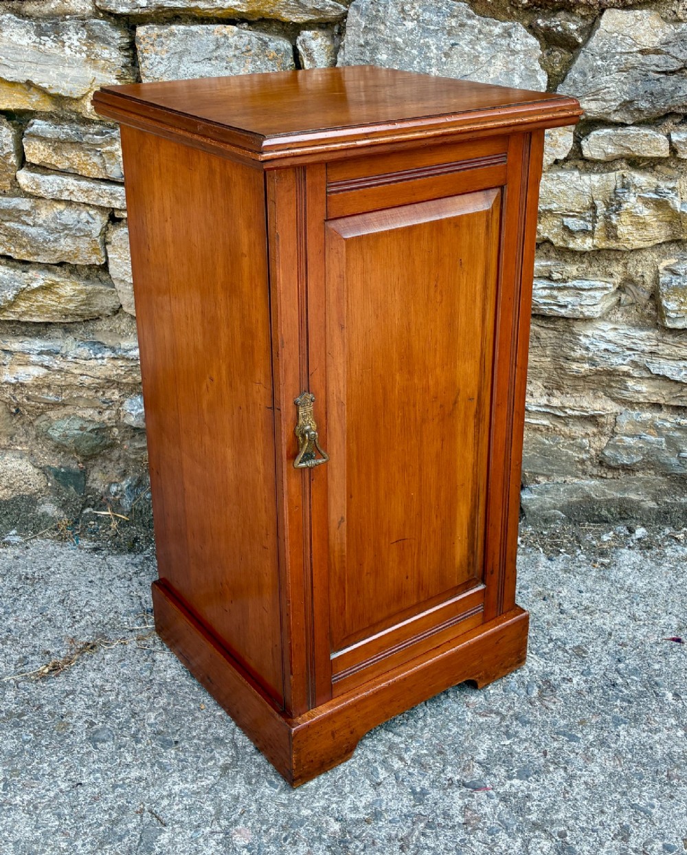 An Edwardian warm brown walnut pot cupboard featuring a single panelled door with a brass handle and reeded side moulding. View XI