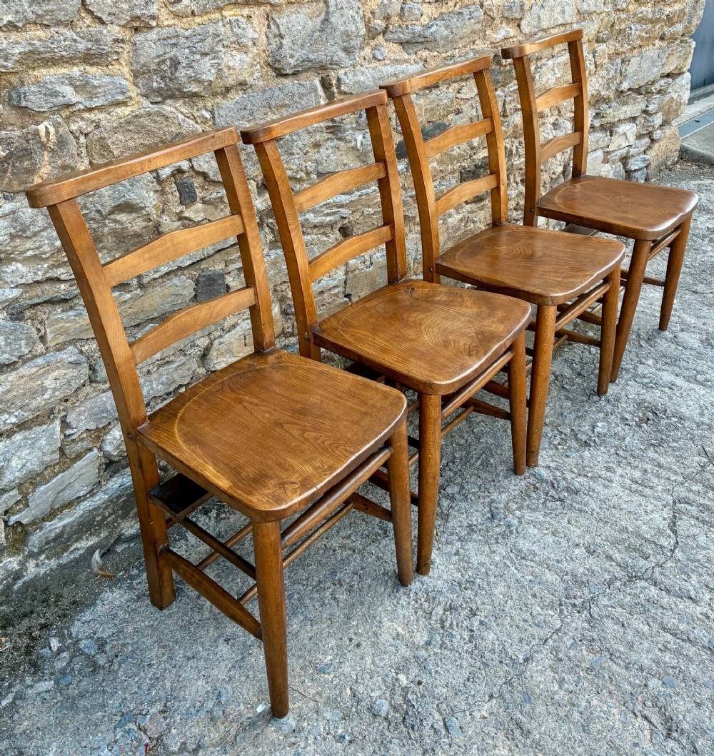 A set of four matching antique wooden chapel chairs with contoured seats and ladder-back rails. View III