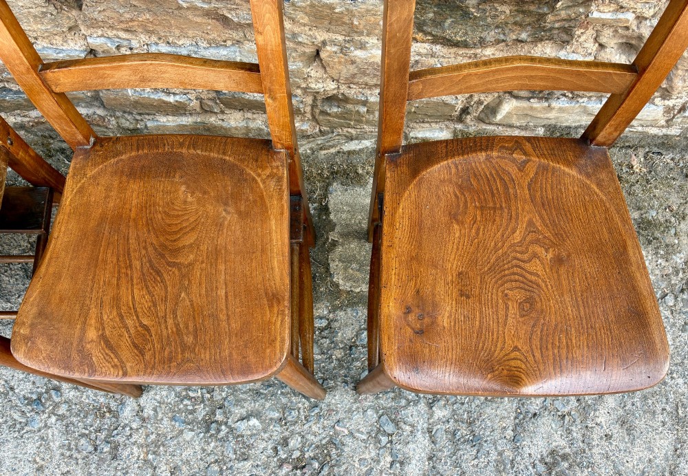 A set of four matching antique wooden chapel chairs with contoured seats and ladder-back rails. View VI