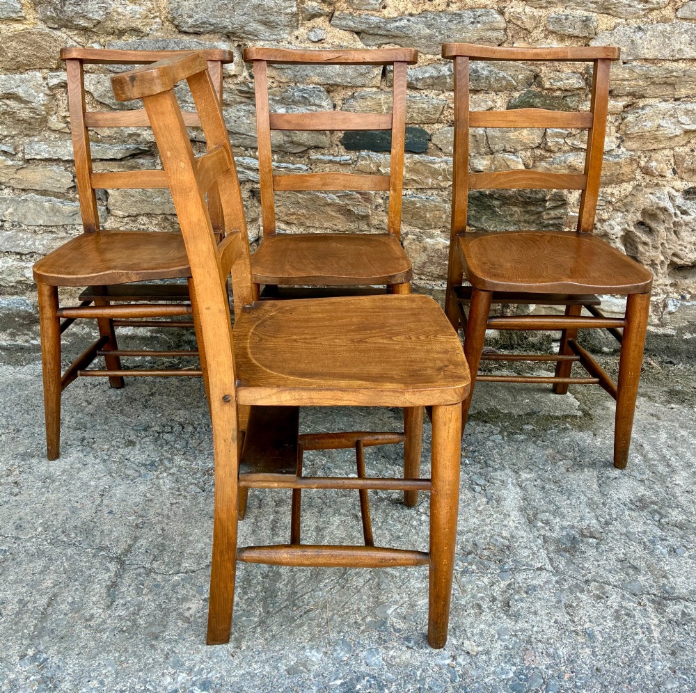 A set of four matching antique wooden chapel chairs with contoured seats and ladder-back rails. View XI