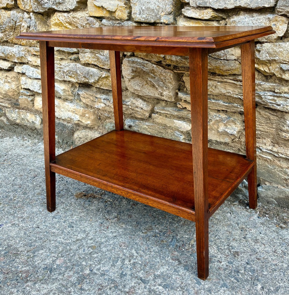 An Arts and Crafts solid oak side table featuring a lower shelf, straight square legs, and dark circular wood inlays arranged in a grid pattern on the top surface. View VI