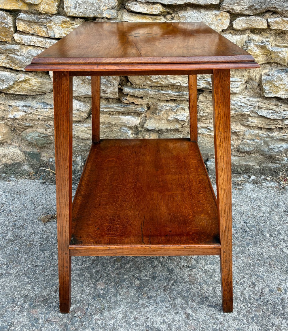 An Arts and Crafts solid oak side table featuring a lower shelf, straight square legs, and dark circular wood inlays arranged in a grid pattern on the top surface. View VII