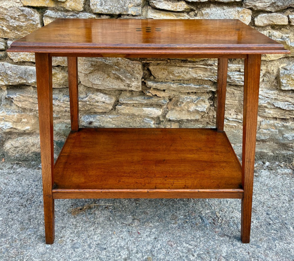 An Arts and Crafts solid oak side table featuring a lower shelf, straight square legs, and dark circular wood inlays arranged in a grid pattern on the top surface. View XI