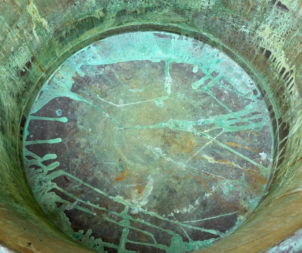 A large circular antique copper wash tub displaying heavy green verdigris oxidisation and two iron side handles. View VI