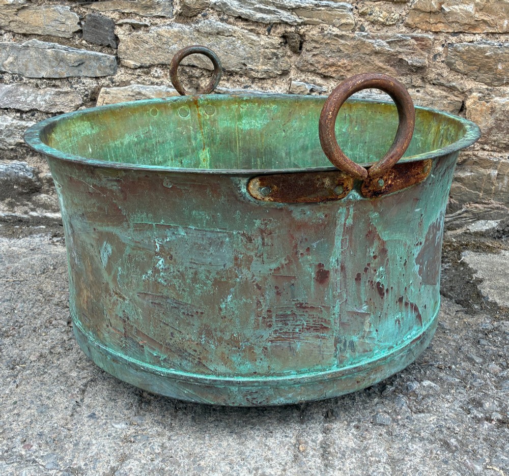 A large circular antique copper wash tub displaying heavy green verdigris oxidisation and two iron side handles. View VII