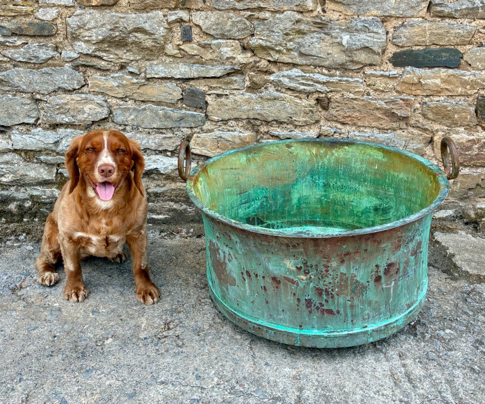 A large circular antique copper wash tub displaying heavy green verdigris oxidisation and two iron side handles. View XI