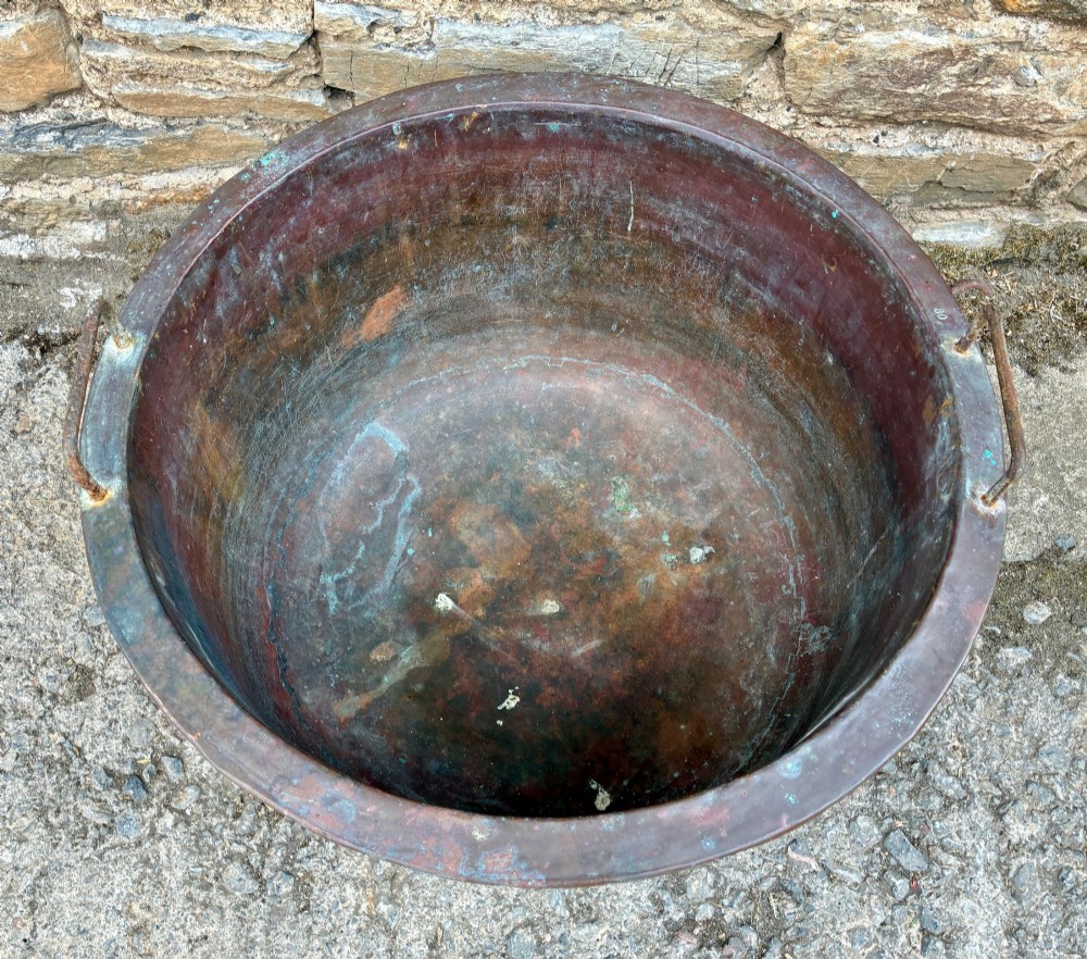 A large, circular antique copper wash tub featuring twin wrought iron carrying handles, a rolled rim, and heavy surface oxidisation with verdigris. View III