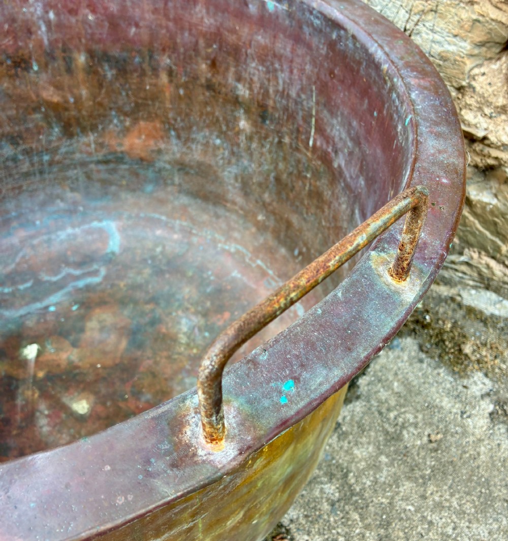 A large, circular antique copper wash tub featuring twin wrought iron carrying handles, a rolled rim, and heavy surface oxidisation with verdigris. View IV
