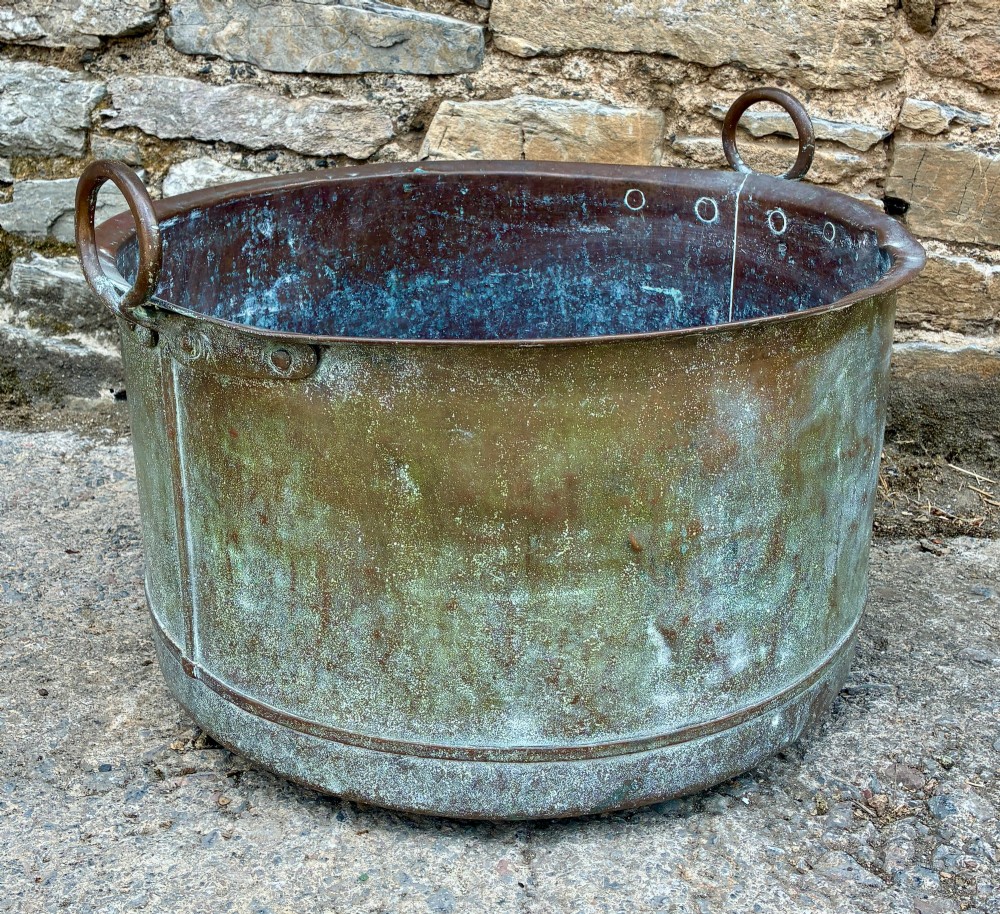 A large cylindrical antique copper wash tub featuring a flared rolled rim, side handles, and a heavily aged green verdigris patina. View VI