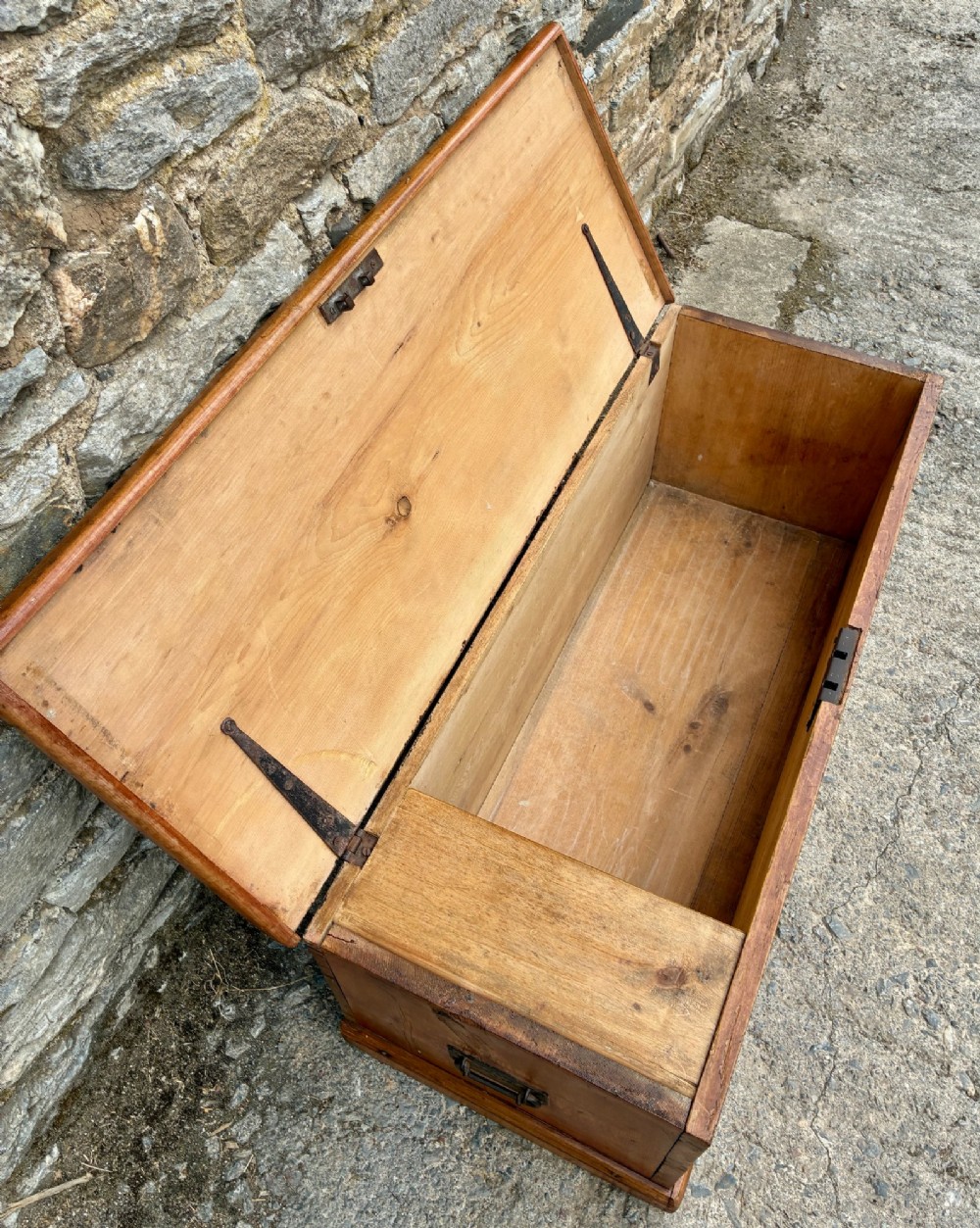 A rectangular pine blanket box featuring a hinged lid, brass keyhole escutcheon, and a low plinth base. View IV
