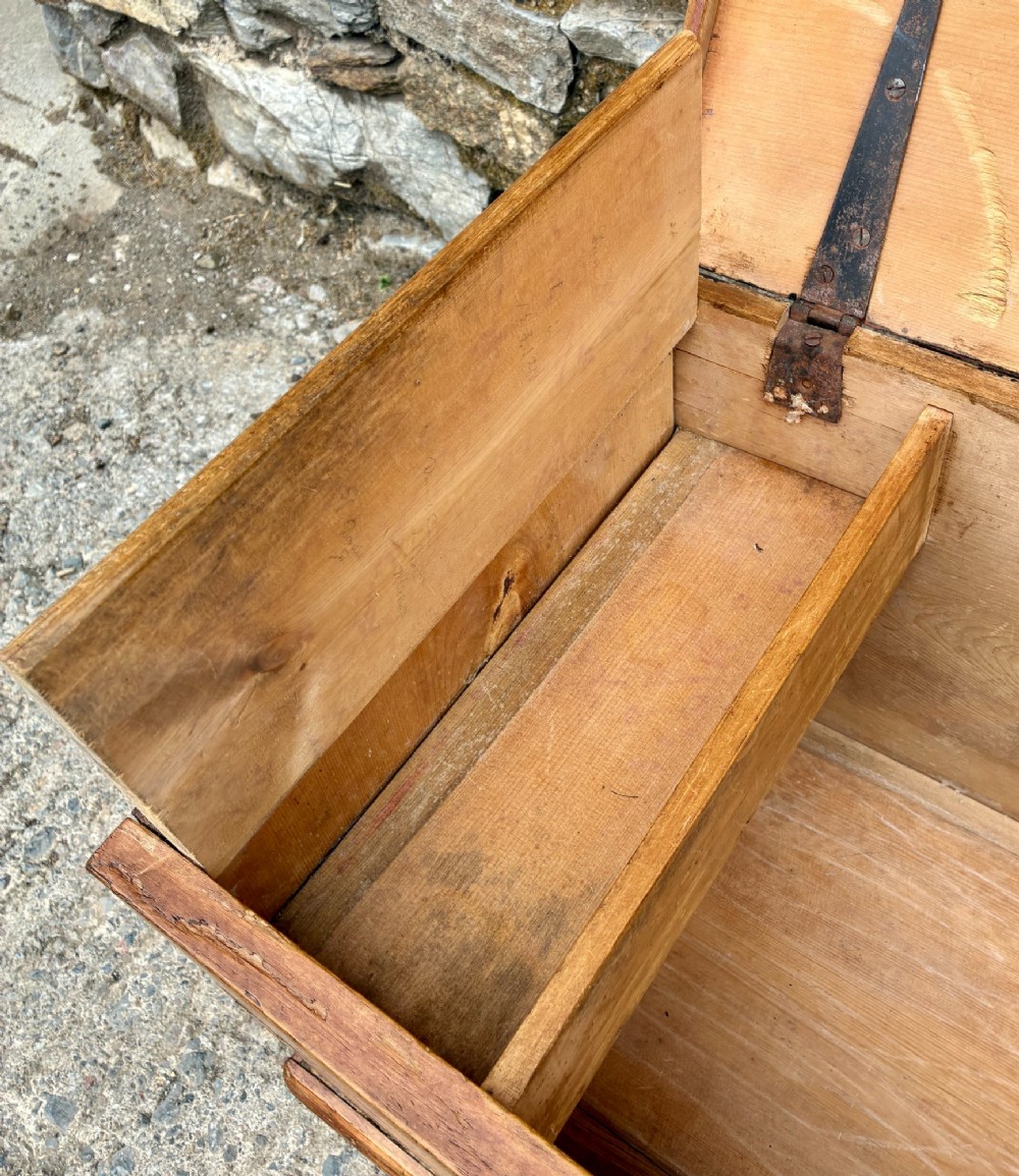 A rectangular pine blanket box featuring a hinged lid, brass keyhole escutcheon, and a low plinth base. View V