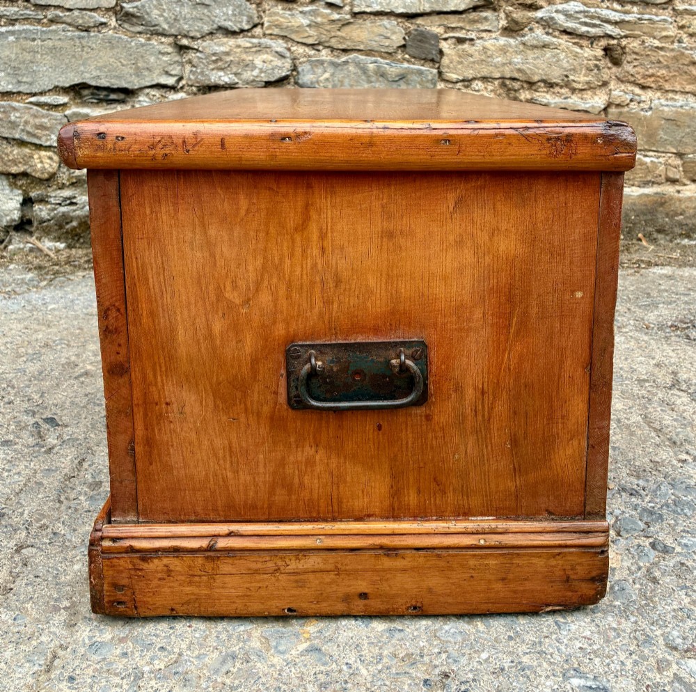 A rectangular pine blanket box featuring a hinged lid, brass keyhole escutcheon, and a low plinth base. View VIII