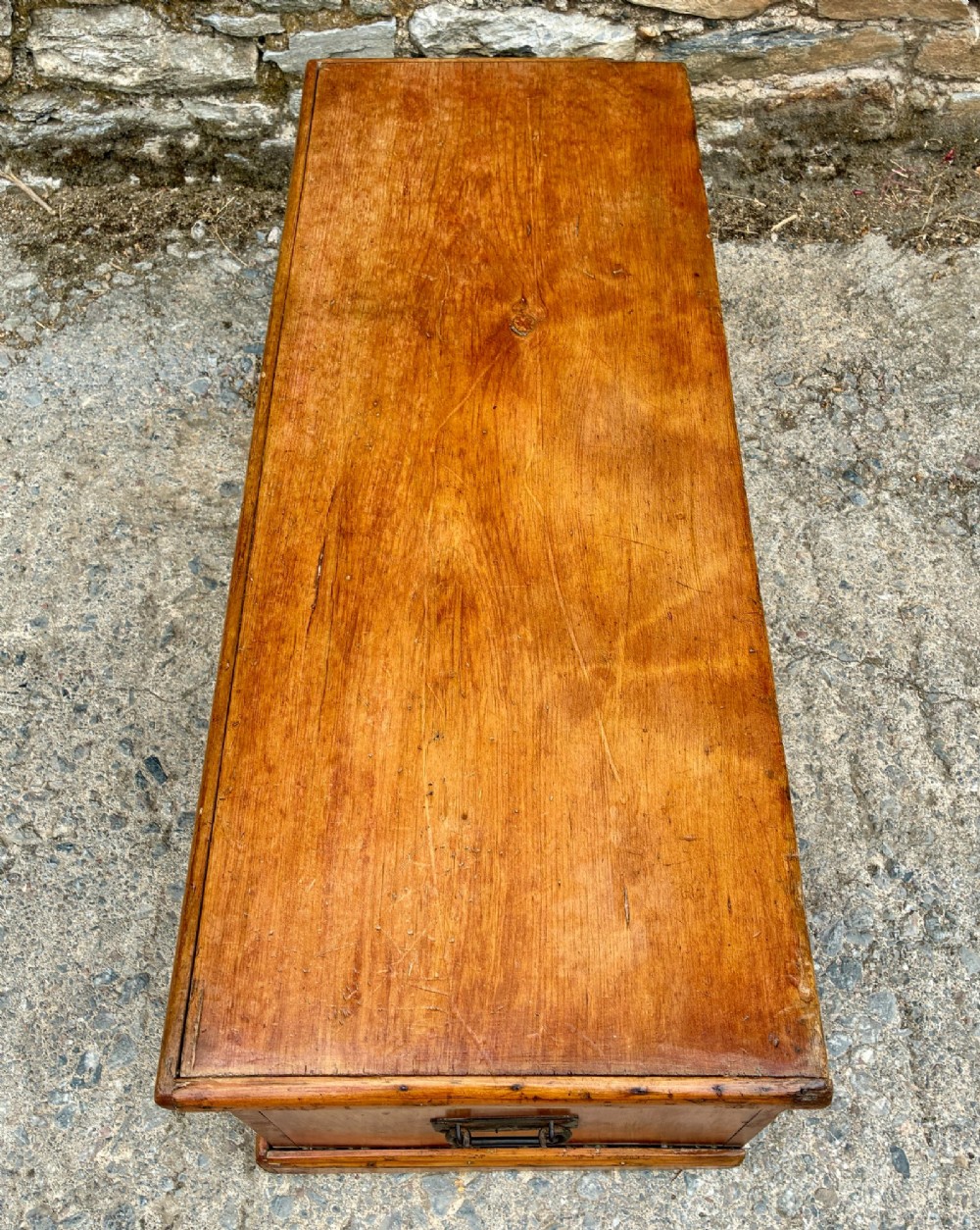 A rectangular pine blanket box featuring a hinged lid, brass keyhole escutcheon, and a low plinth base. View IX