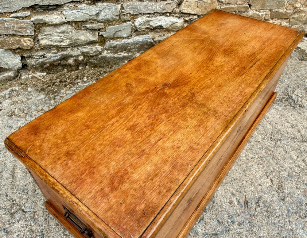 A rectangular pine blanket box featuring a hinged lid, brass keyhole escutcheon, and a low plinth base. View XV