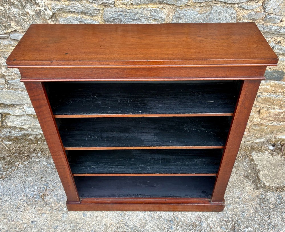 An antique Victorian open mahogany bookcase with four adjustable shelves and a dark painted interior. View II