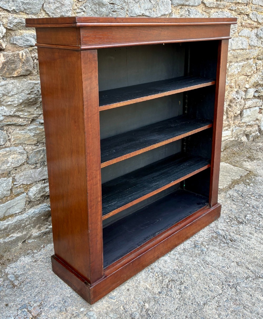 An antique Victorian open mahogany bookcase with four adjustable shelves and a dark painted interior. View III