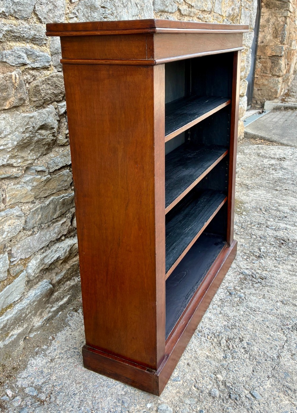 An antique Victorian open mahogany bookcase with four adjustable shelves and a dark painted interior. View IV