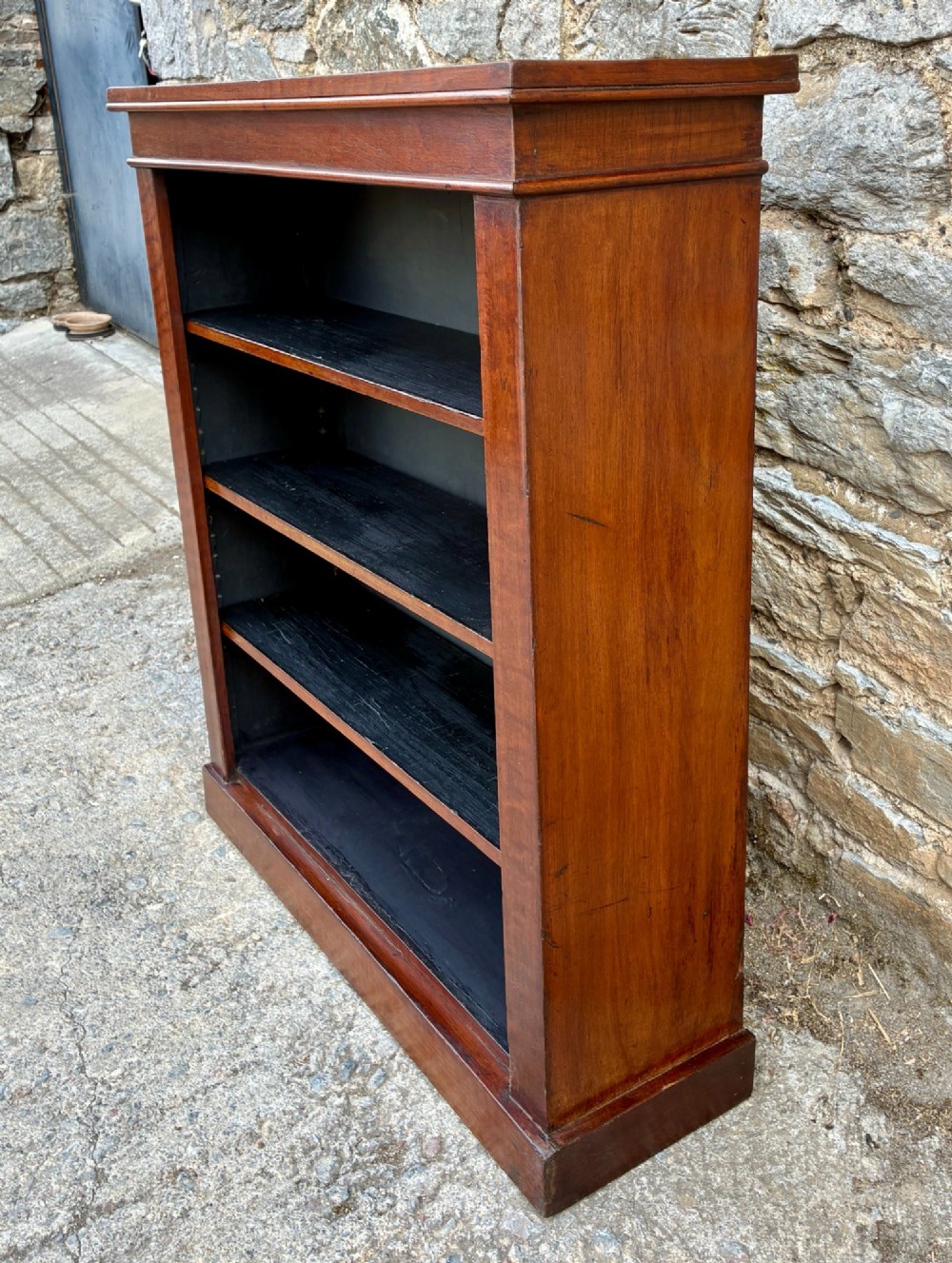An antique Victorian open mahogany bookcase with four adjustable shelves and a dark painted interior. View V
