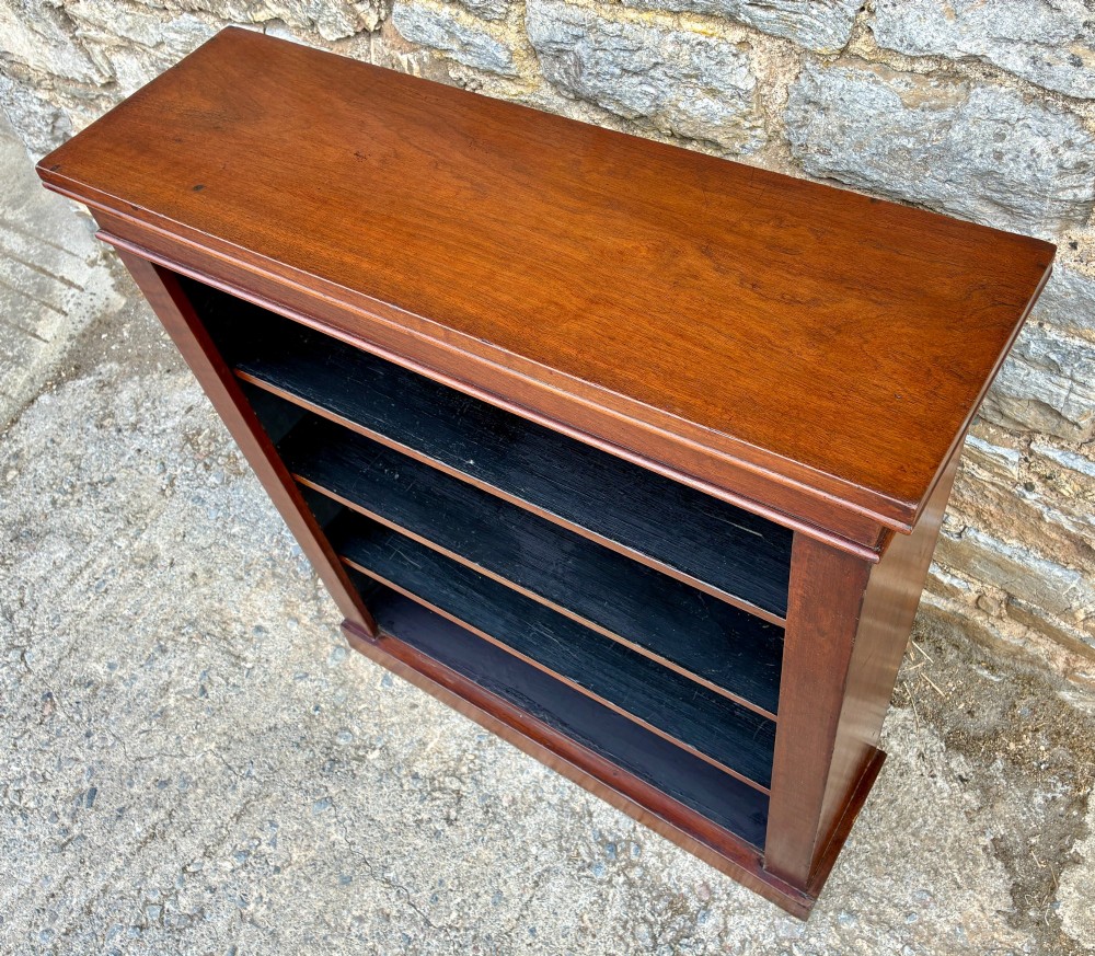 An antique Victorian open mahogany bookcase with four adjustable shelves and a dark painted interior. View VI