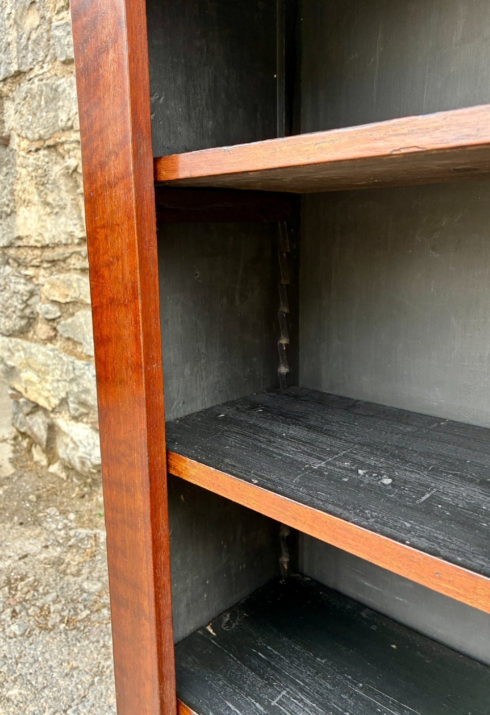 An antique Victorian open mahogany bookcase with four adjustable shelves and a dark painted interior. View VII