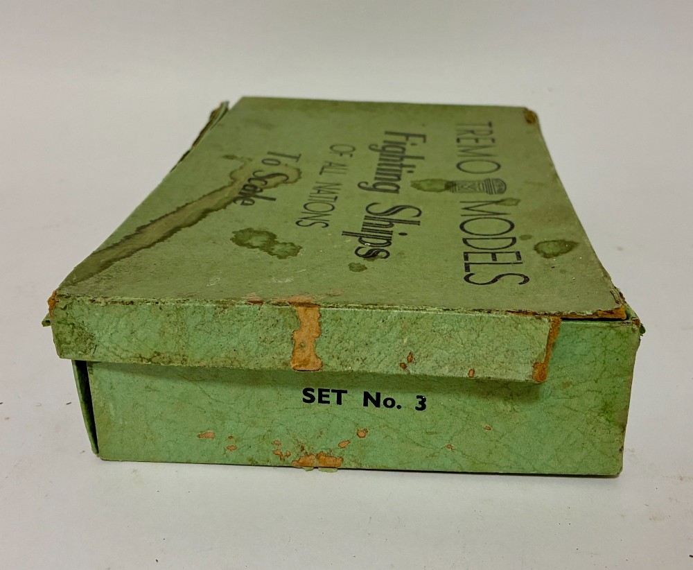 A vintage green cardboard box containing a set of miniature diecast metal model warships of the British Navy. View VII