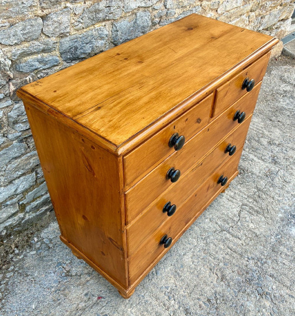 An antique warm pine chest of drawers featuring a two-over-three drawer arrangement with dark turned wooden knobs. View IV
