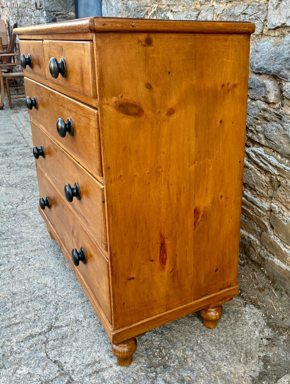 An antique warm pine chest of drawers featuring a two-over-three drawer arrangement with dark turned wooden knobs. View VI