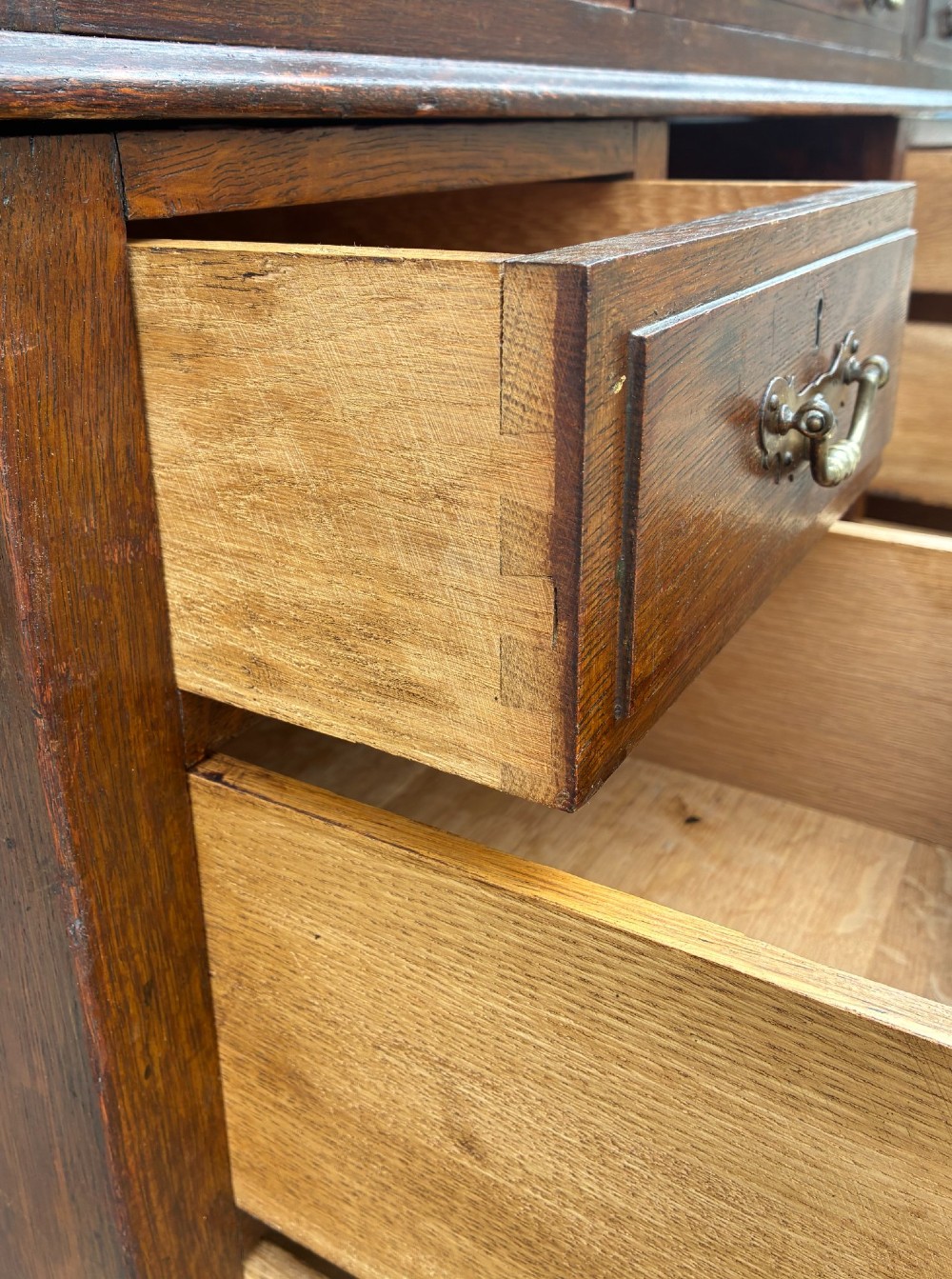 An Edwardian oak pedestal desk featuring a green leather writing surface, nine drawers with brass handles, and twin pedestals on plinth bases. View XI