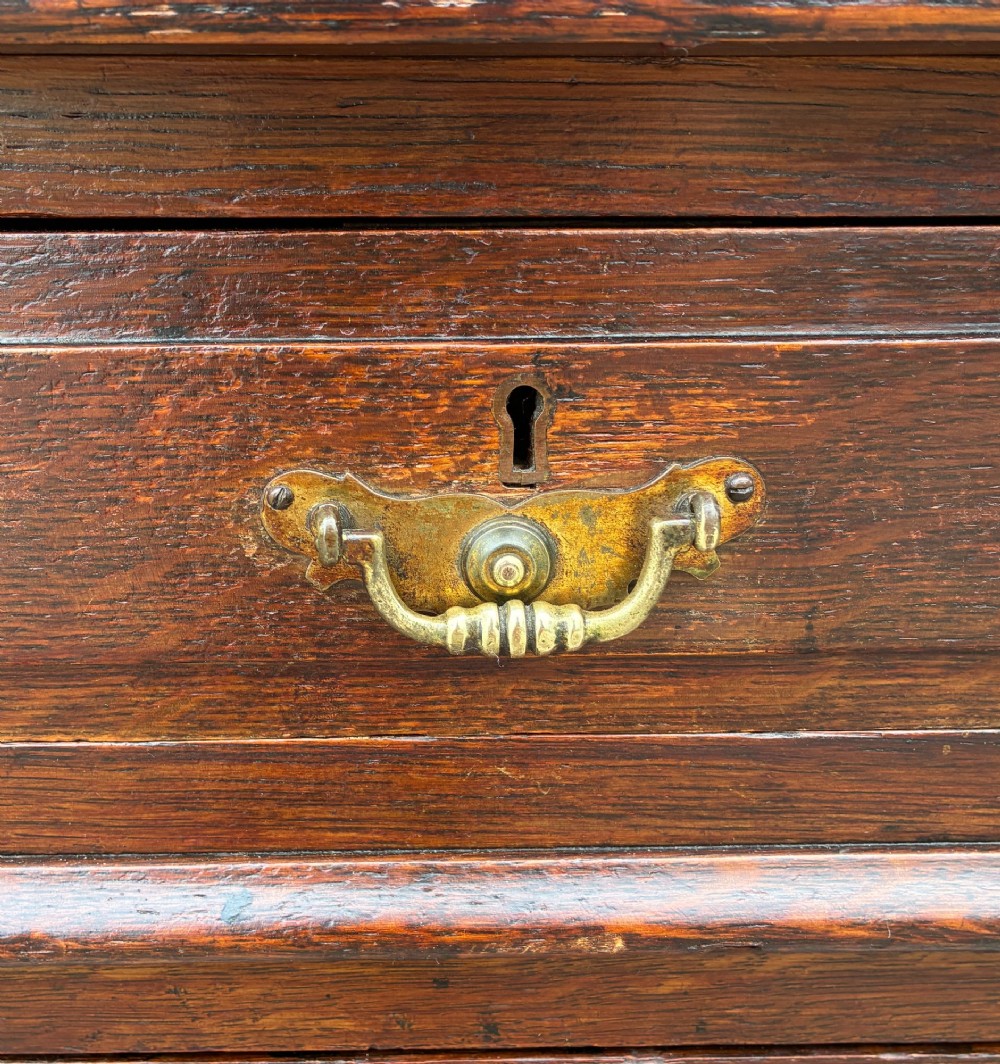An Edwardian oak pedestal desk featuring a green leather writing surface, nine drawers with brass handles, and twin pedestals on plinth bases. View XIII