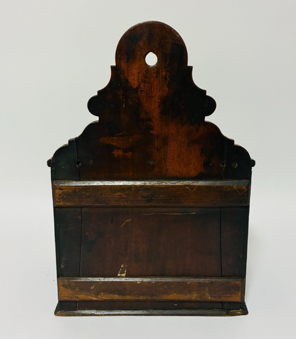 A dark mahogany Georgian hanging salt box with a curved hinged lid and a shaped backplate featuring a circular hanging hole. View VII