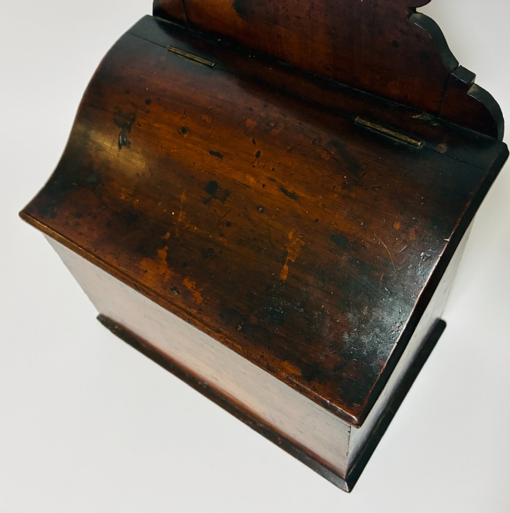 A dark mahogany Georgian hanging salt box with a curved hinged lid and a shaped backplate featuring a circular hanging hole. View XI