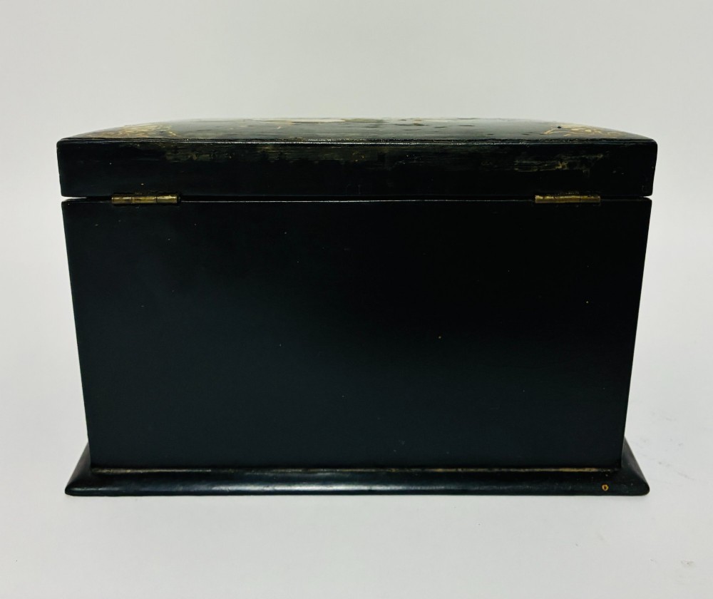 A black lacquered Victorian papier-mache stationery box featuring mother-of-pearl flower inlays on the lid and gilded corner scrollwork around a central brass keyhole. View VII