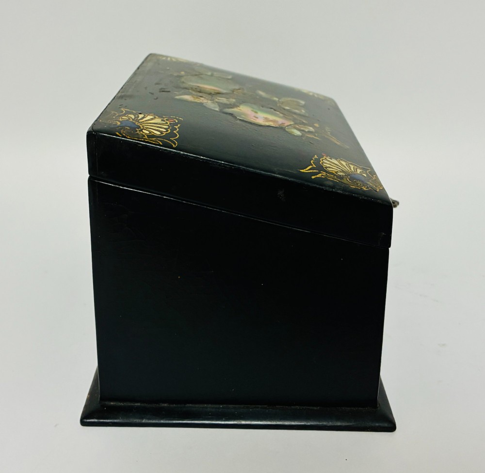 A black lacquered Victorian papier-mache stationery box featuring mother-of-pearl flower inlays on the lid and gilded corner scrollwork around a central brass keyhole. View VIII