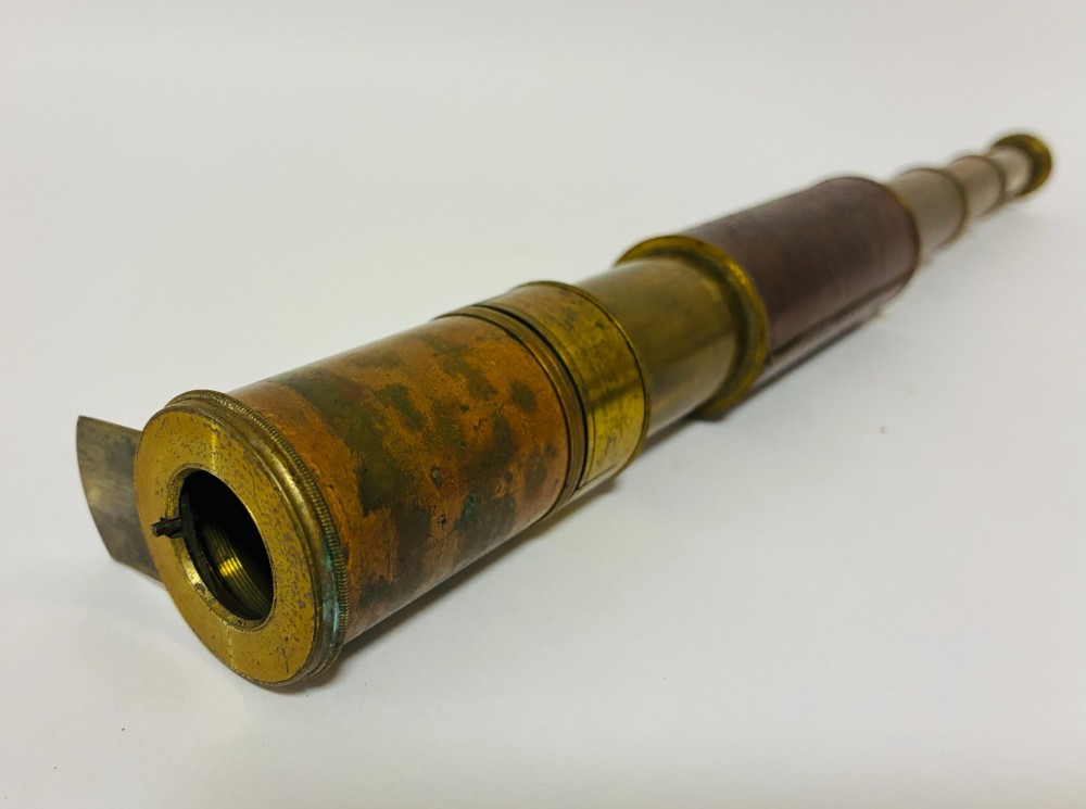 An extended three-draw antique brass pocket telescope featuring a dark brown textured leather barrel wrap. View IV