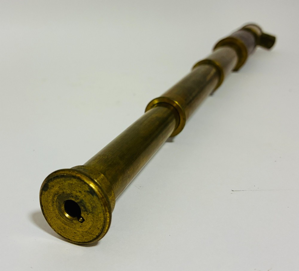 An extended three-draw antique brass pocket telescope featuring a dark brown textured leather barrel wrap. View VII