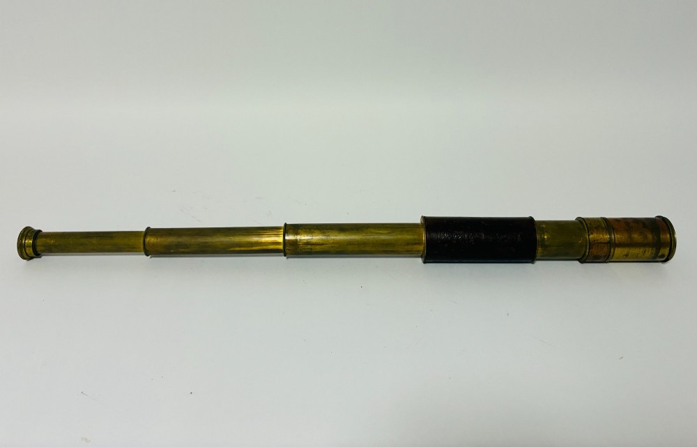 An extended three-draw antique brass pocket telescope featuring a dark brown textured leather barrel wrap. View VIII
