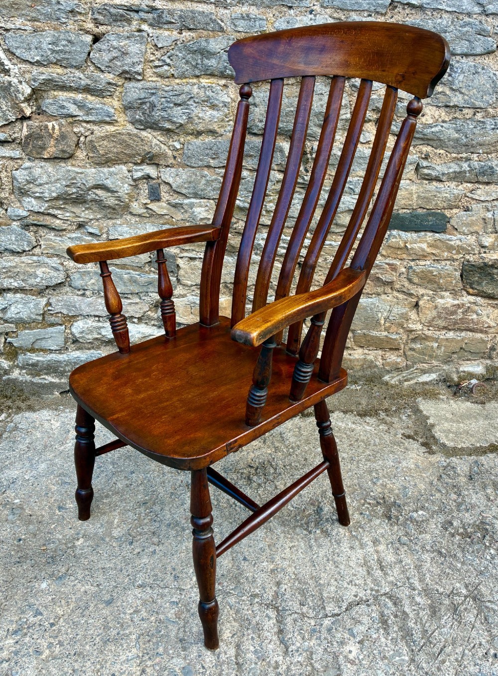 A Victorian country lath back armchair in warm brown wood, featuring vertical back slats, curved armrests, a contoured seat, and turned legs. View III