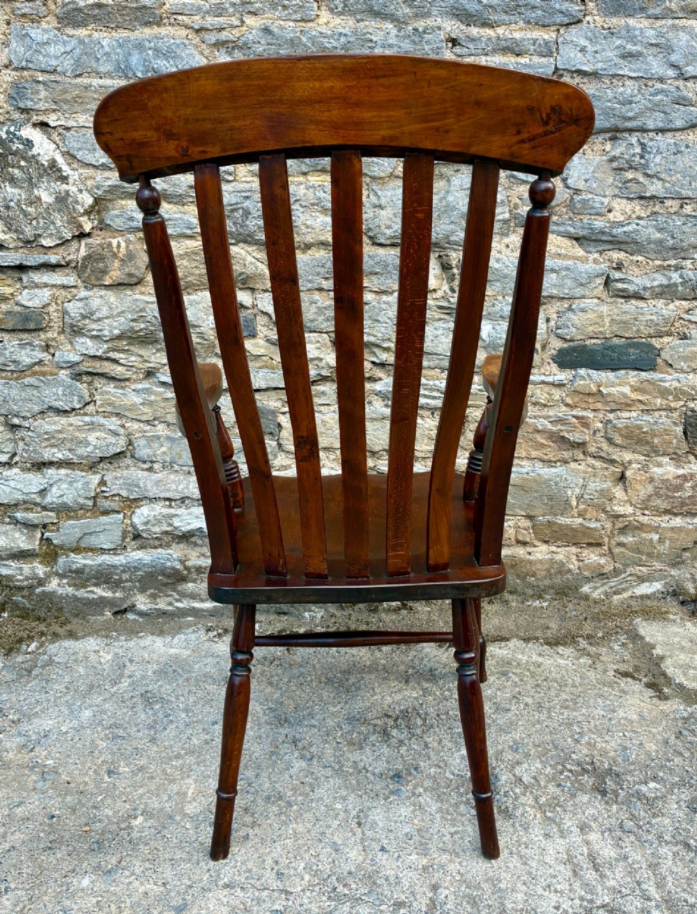 A Victorian country lath back armchair in warm brown wood, featuring vertical back slats, curved armrests, a contoured seat, and turned legs. View V
