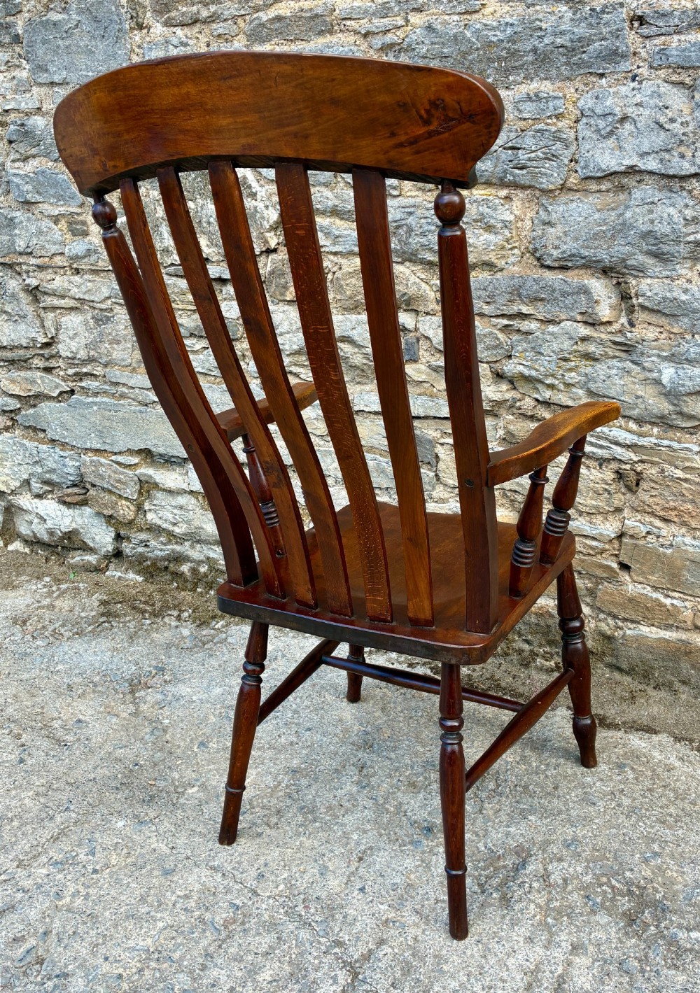 A Victorian country lath back armchair in warm brown wood, featuring vertical back slats, curved armrests, a contoured seat, and turned legs. View VII