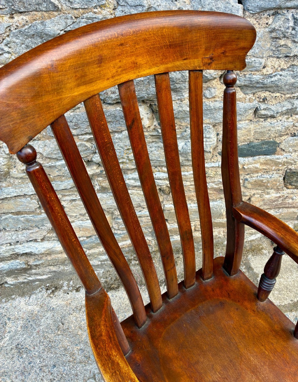 A Victorian country lath back armchair in warm brown wood, featuring vertical back slats, curved armrests, a contoured seat, and turned legs. View XI