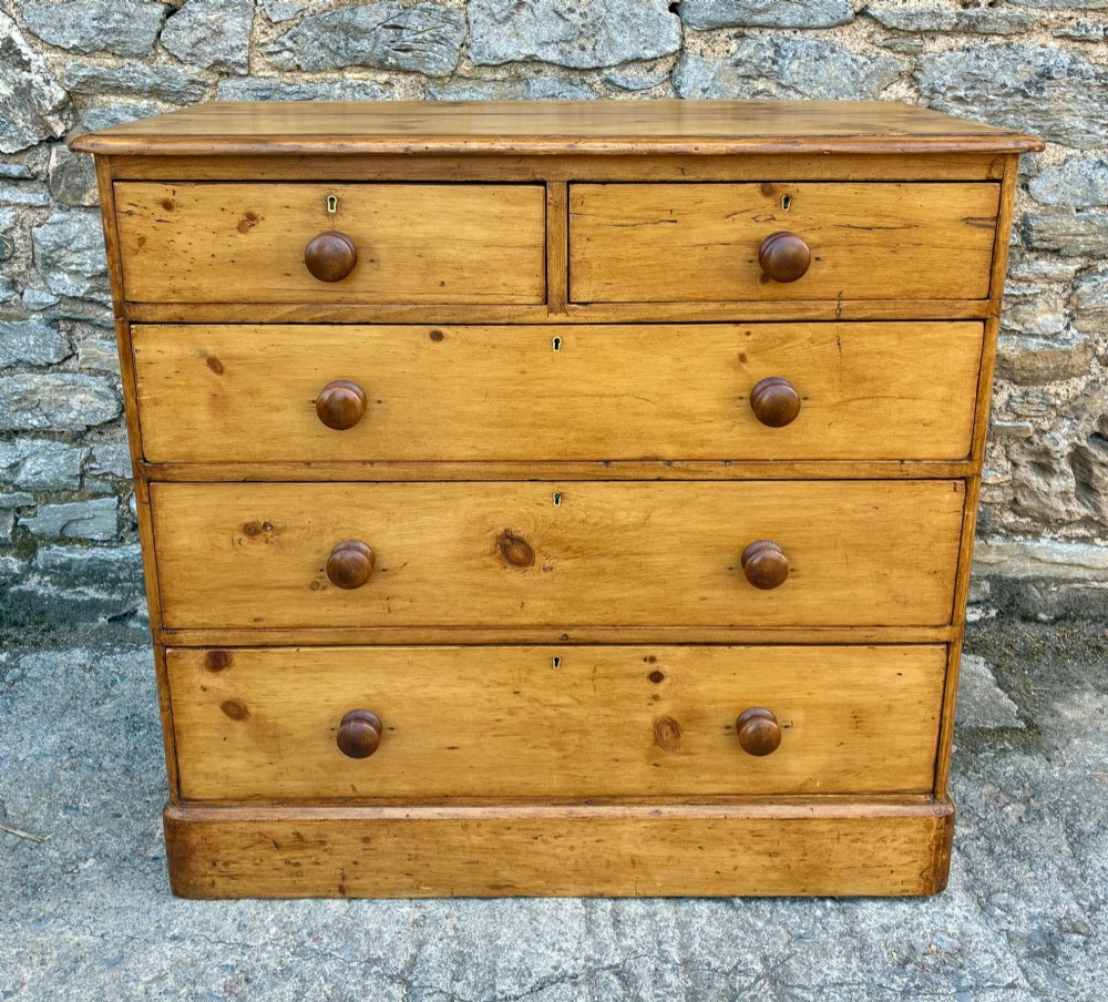 A Victorian pine chest of drawers featuring a two short over three long drawer arrangement with turned wooden knobs. View II