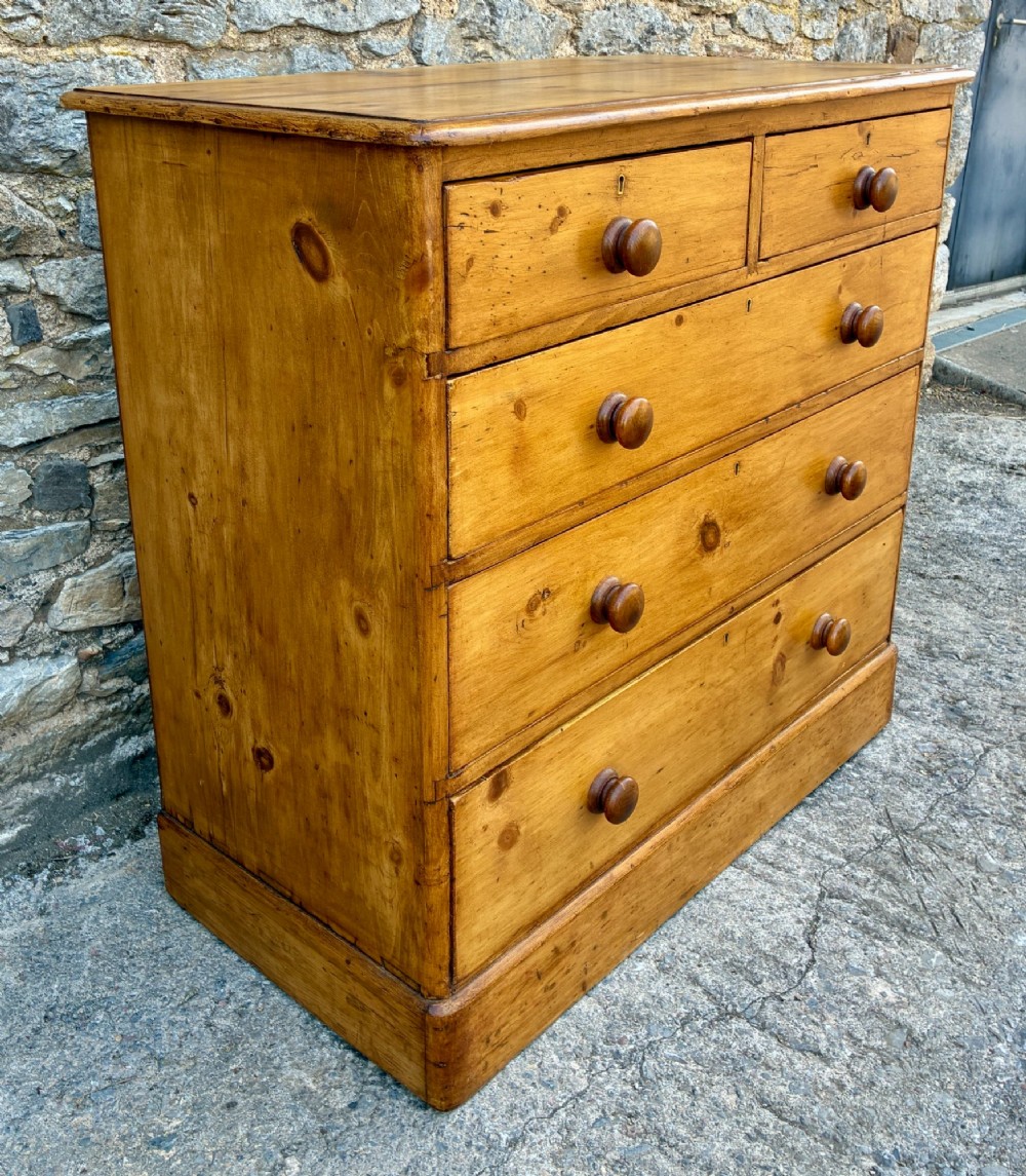 A Victorian pine chest of drawers featuring a two short over three long drawer arrangement with turned wooden knobs. View III